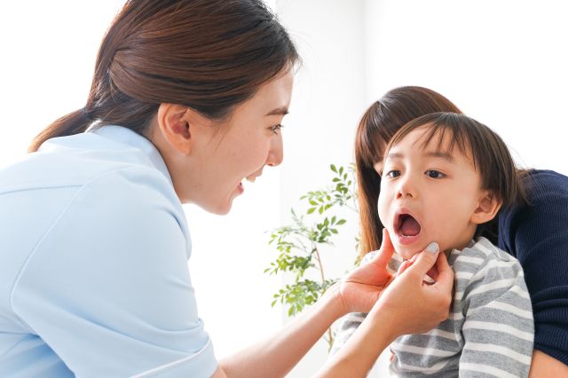 子どもの歯を確認する女性歯科スタッフ
